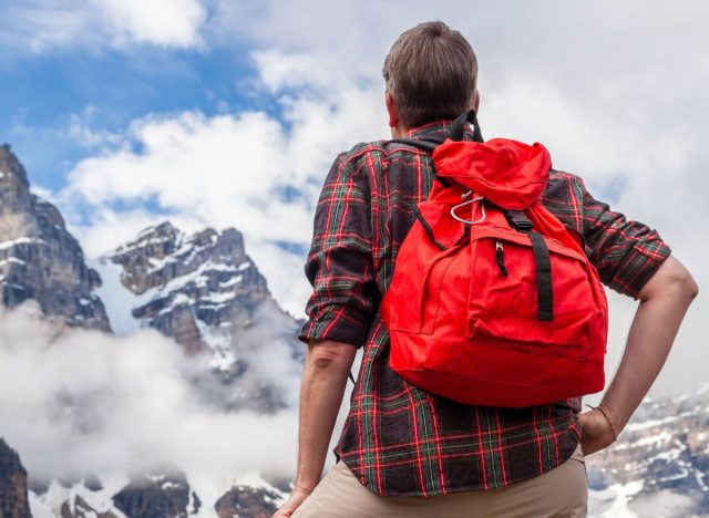 man hiking mountain terrain with rucksack