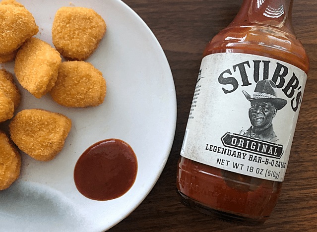a bottle of stubbs bbq sauce with chicken nuggets next to it