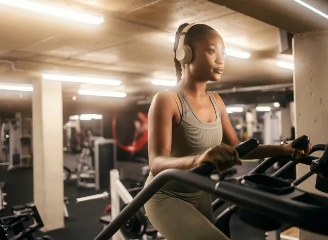 focused woman using a stairmaster machine at the gym