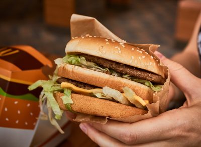 A closeup of McDonald's Big Mac in a woman's hand