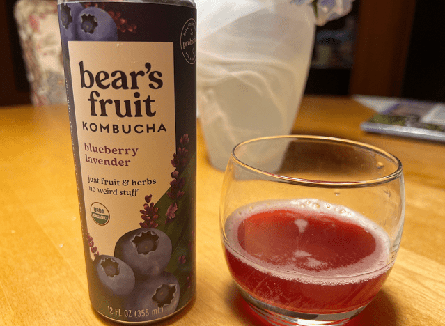 a can of bear's fruit blueberry lavender kombucha next to a glass of it 
