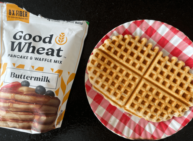 good wheat waffle mix in a bag next to a waffle on a plate 