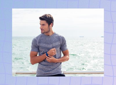 fit man checking his fitness tracker while on a walk