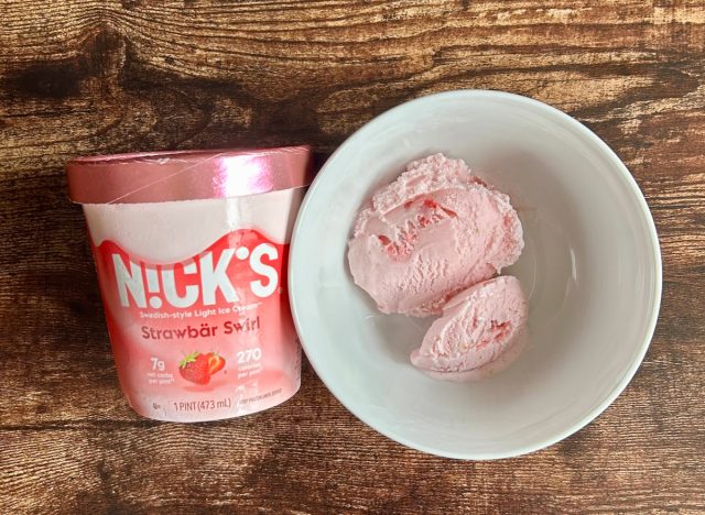 pint of nicks strawbär swirl light ice cream next to a bowl of the ice cream