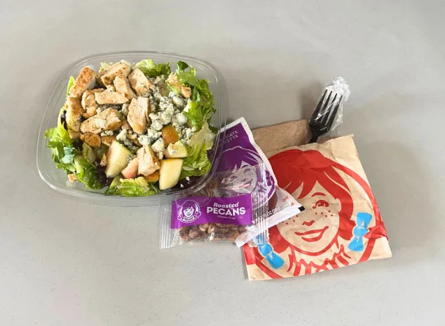 Wendy's Apple Pecan Salad and toppings on a countertop