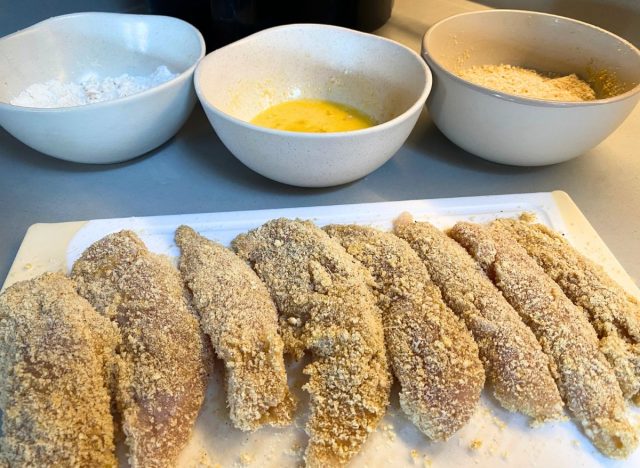 Breaded chicken tenders in front of three bowls