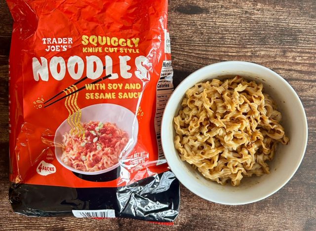 trader joe's squiggly knife cut style noodles in a bowl next to a package of the noodles