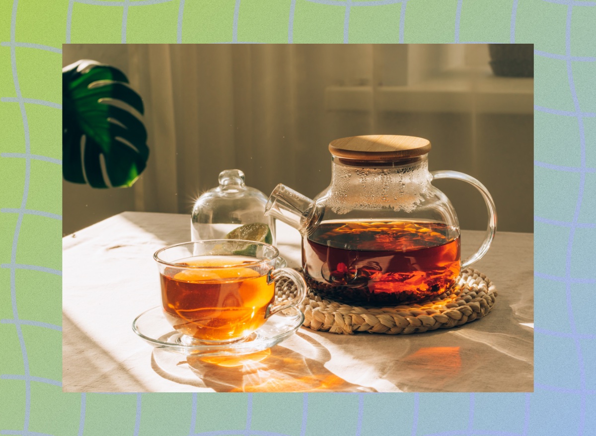 green tea cup and kettle on table with sunlight pouring onto them