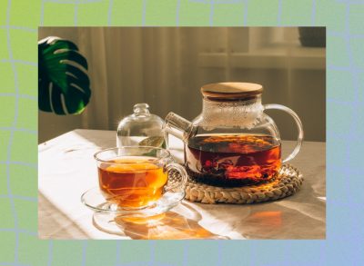 green tea cup and kettle on table with sunlight pouring onto them