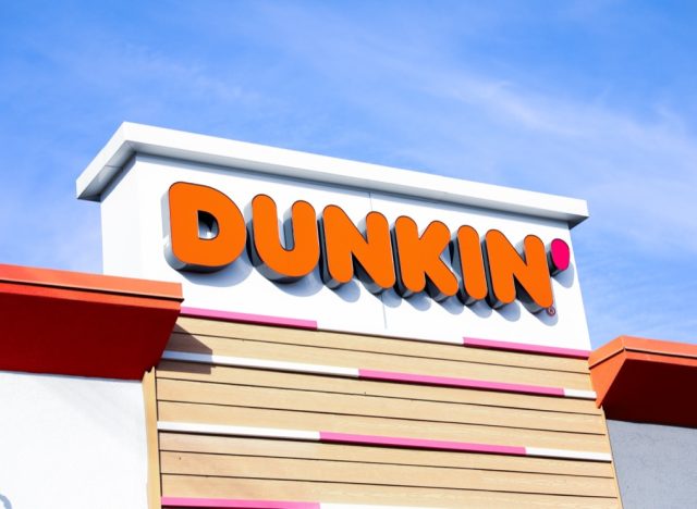 Chicago, IL, USA, December 3, 2023, Dunkin' Donuts sign illuminating a stack of branded boxes, inviting and delicious treats on display