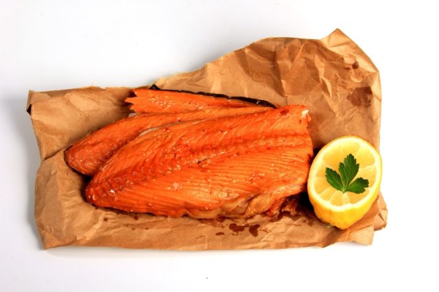 Hot smoked salmon trim and leftovers with bones and fins on white background