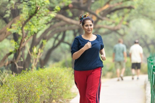 Senior couple, dog walk and nature park road during exercise, walking and leisure during a stroll through the woods. Old man and woman being active for energy and living healthy with a pet outside