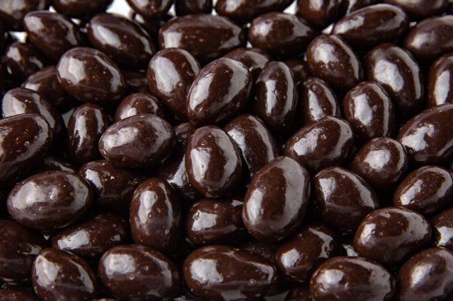 Candy. Dark chocolate almonds. Desserts for candy bars. Small white drages