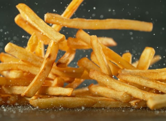 Flying French Fries Falling on Table. Fast Food Concept with Flying Food.