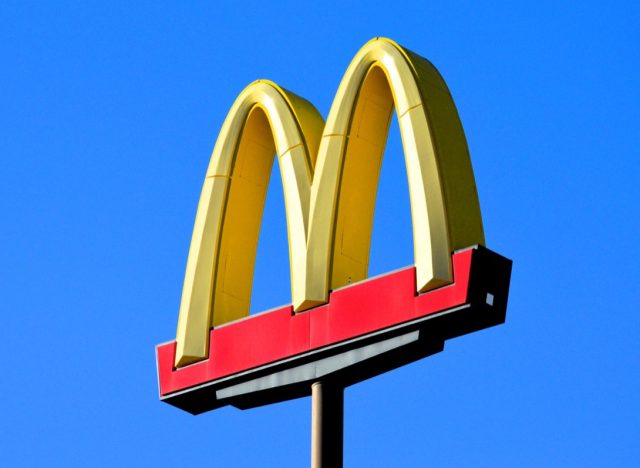 Phoenix, Arizona - Dec. 01 2023: A McDonalds famous golden arches sign at one of their restaurant locations along Interstate 10 south of Phoenix. (sign has logo with no words against bright blue sky)
