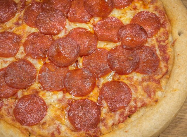 Pepperoni Pizza Up Close Studio Shot against a wooden background