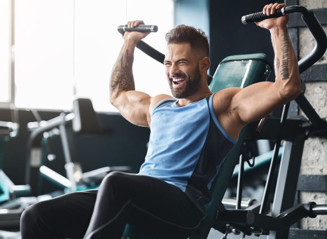 Chest exercise. Handsome muscular man working out hard at gym, free space