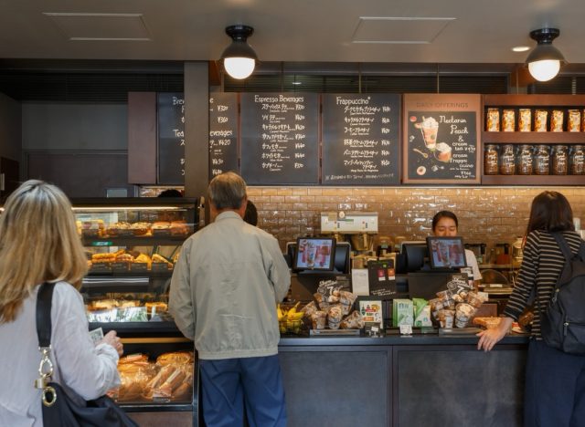 Tokyo, Japan. September 8, 2023 : student working at past time barista at busy morning in coffee shop. Clients order coffee, bread and breakfast in Starbuck coffeeshop before going to work or travel.