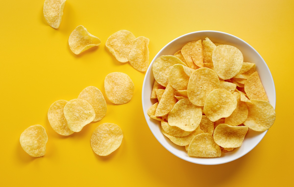 Close up,Of,Potato,Chips,Or,Crisps,In,Bowl,Against,Yellow