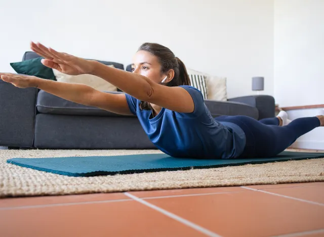 Woman Working Out at Home Superman Exercise for the Back, Superman holds 