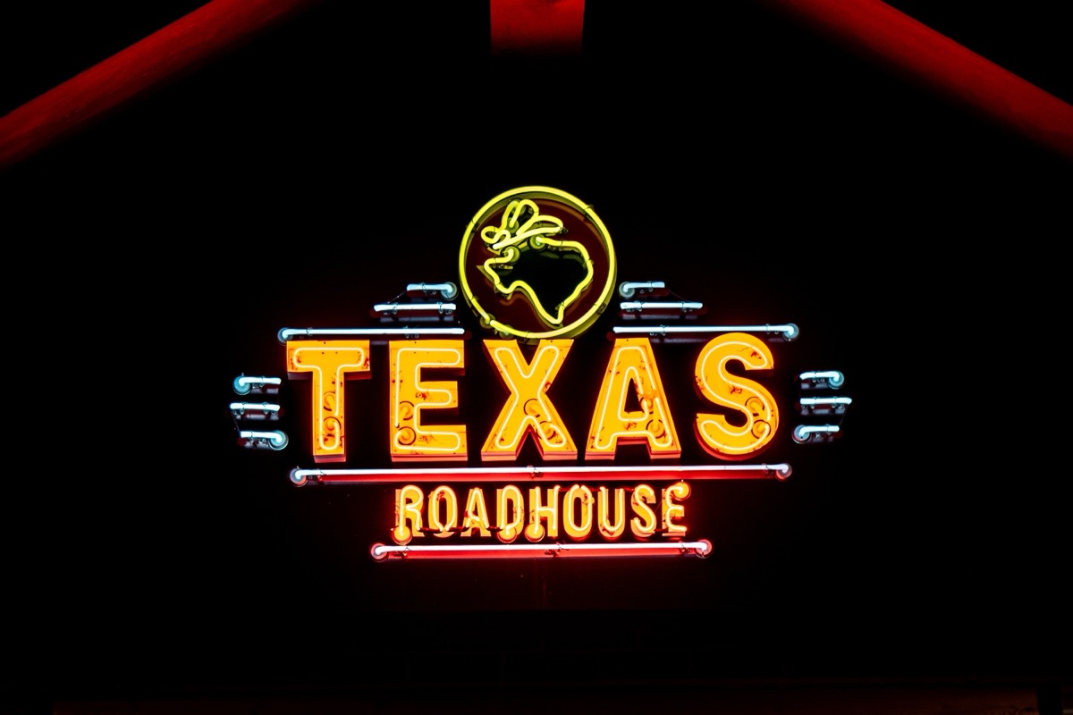 WOODBURY, MN, USA - DECEMBER 4, 2023: Texas Roadhouse restaurant exterior and trademark logo at night.