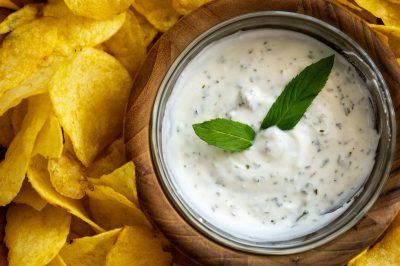 Eating chips with spicy yoghurt on a plate dip yoghurt chips eating chips with sauce