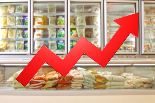 Rising food prices. Up arrow near supermarket shelves. Food inflation. Refrigerators from grocery store blurred. Rising prices due to inflation. Increasing cost of frozen food. Grocery inflation