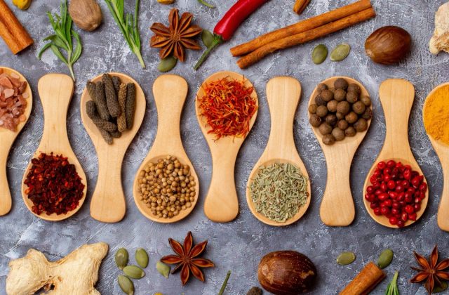 A set of spices on a gray background. Variety of spices from India. Food decoration design. Various spices, peppers and herbs close-up top view. Set of peppers, salt, herbs and spices for cooking.