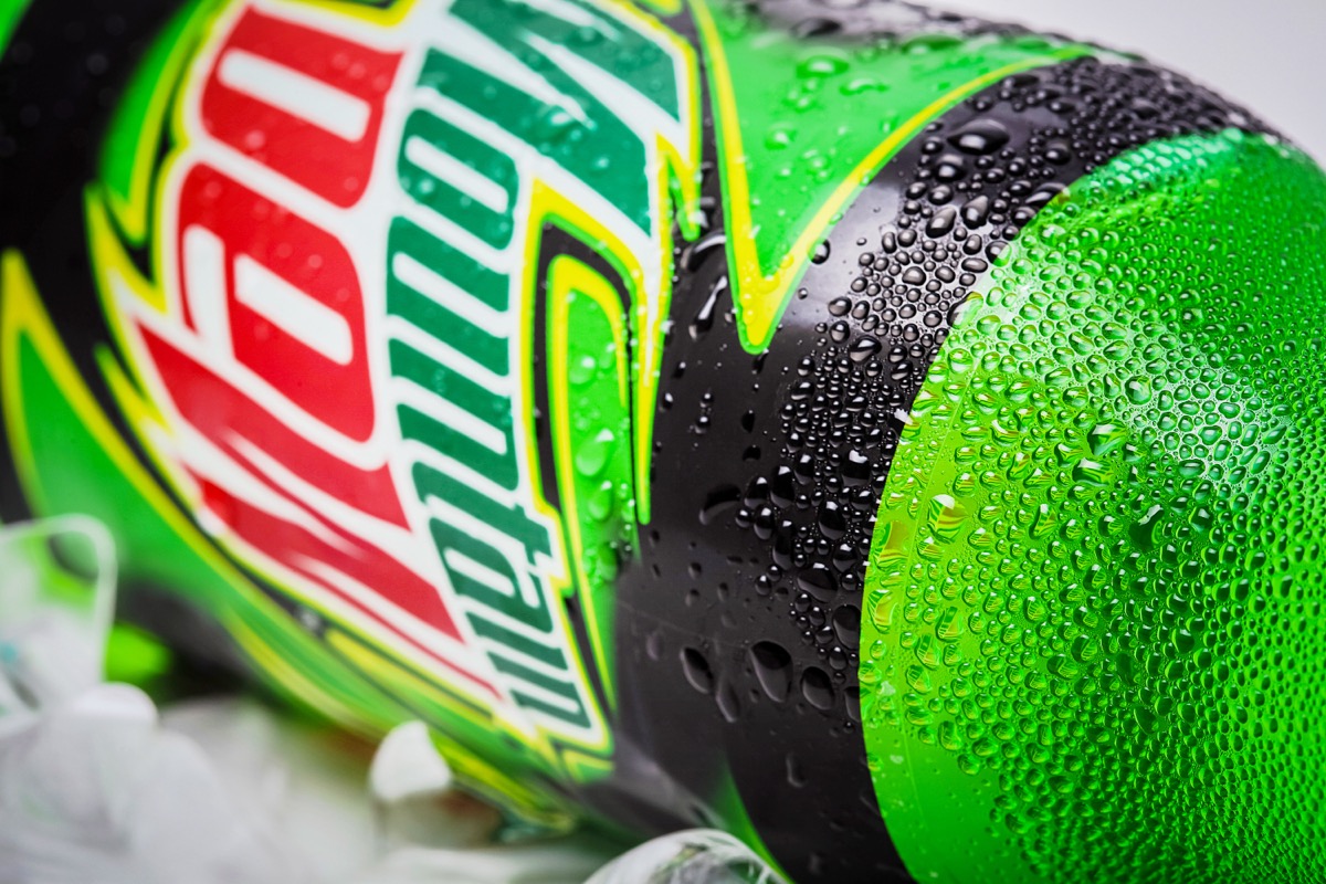 SABAH, MALAYSIA - january 13, 2015: Bottle of Mountain Dew drink on ice isolated on white. Mountain Dew citrus-flavored soft drink produced by PepsiCo. Mountain Dew was introduced in 1940
