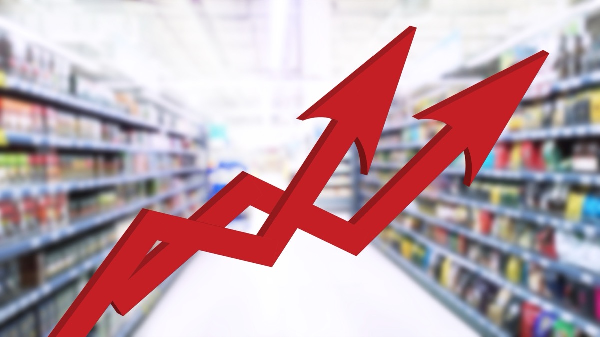 Two red growing up large arrow on abstract blur image of supermarket background. Bar charts and graphs. Rising product prices. Inflation concept. Finance and Economy. Grocery store. Global food crisis
