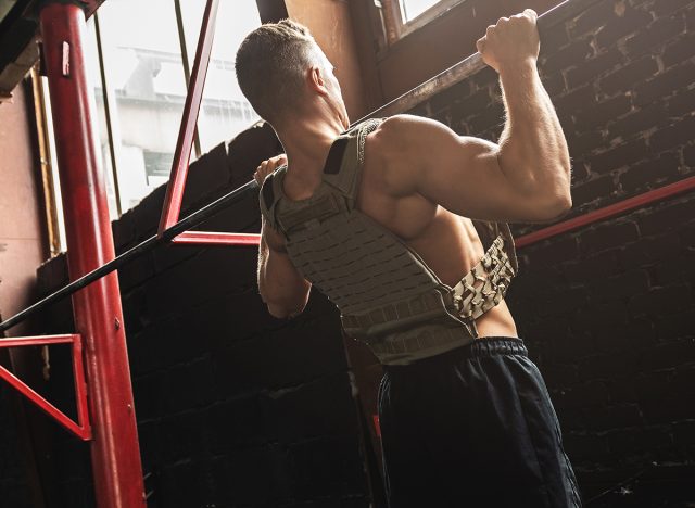 Man doing pull up exercise. Sportsman during his workout in the gym.