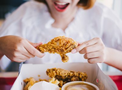Woman eating fried chicken.