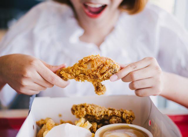 Woman eating fried chicken.