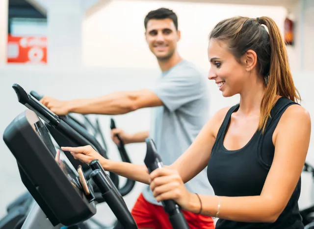 Adult couple is working out on Step climber machine in fitness gym for healthy lifestyle concept.