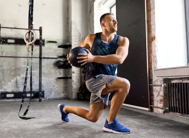 sport, bodybuilding, fitness and people concept - young man exercising with medicine ball in gym