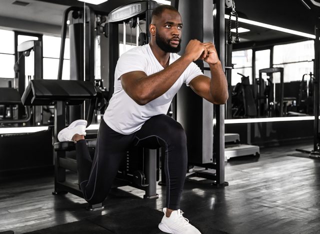 Strong african sportsman doing bulgarian lunges in a gym