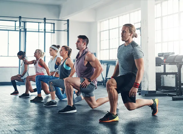People, gym and lunges for fitness workout together, group and health club training for leg strength. Strong body, balance and exercise determination with posture, collaboration and challenge