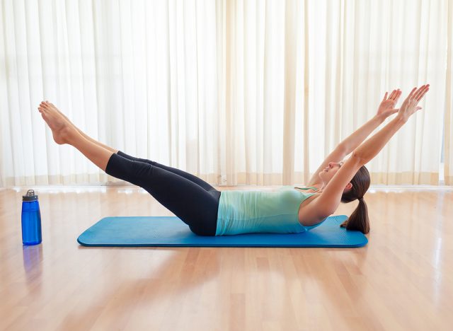 Young woman exercising. (V-ups exercise) Abs core workout.