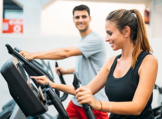 Adult couple is working out on Step climber machine in fitness gym for healthy lifestyle concept. Stair Master 