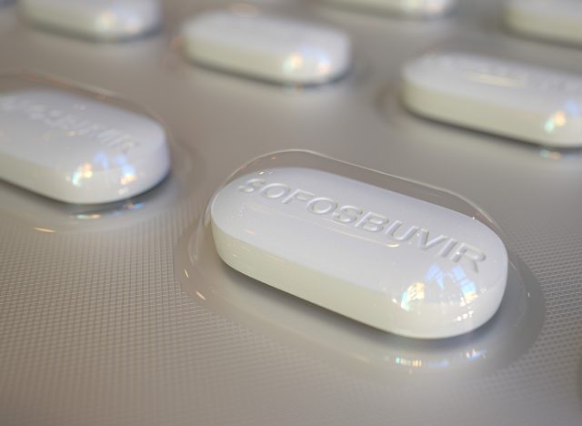 Sofosbuvir generic drug pills in blister pack, close-up 3D rendering