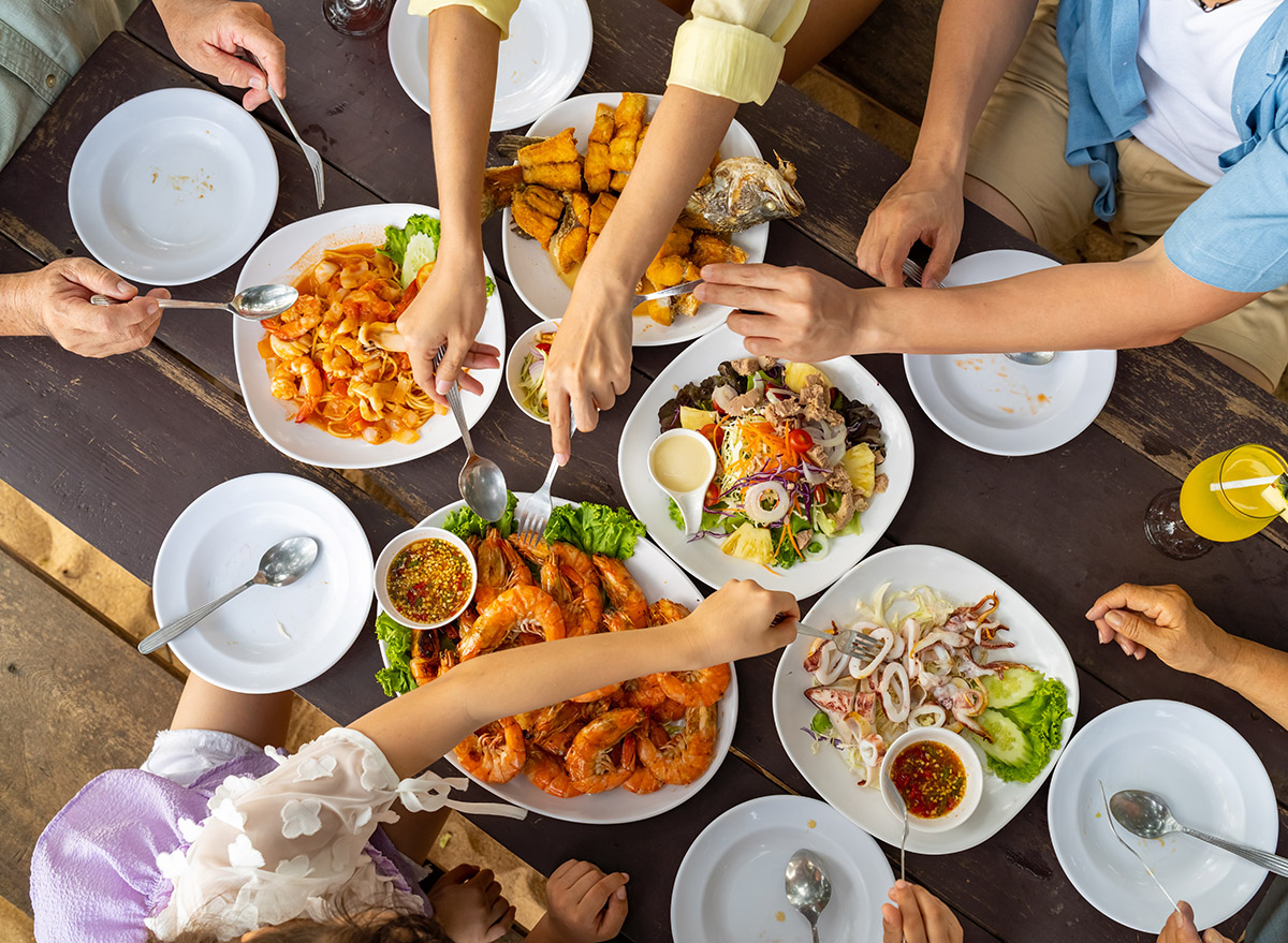 family enjoy and fun spending time together having lunch eating seafood at beach restaurant during travel nature ocean at tropical island on summer holiday vacation.