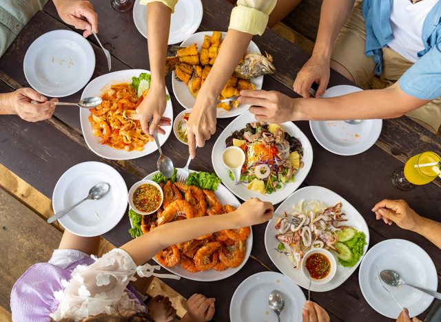 family enjoy and fun spending time together having lunch eating seafood at beach restaurant during travel nature ocean at tropical island on summer holiday vacation.