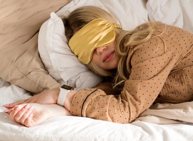 Comfortable sleep with golden eye mask. Healthy sleep for a young, attractive woman