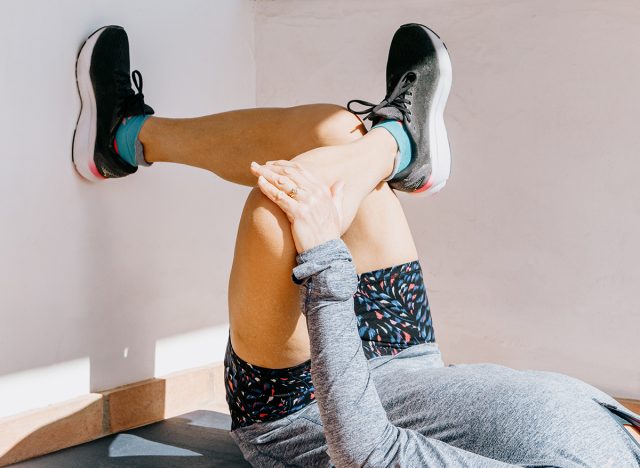 Close-up of woman doing figure 4 stretch for post-run recovery