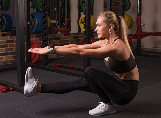 Fitness woman doing pistol squat in the gym