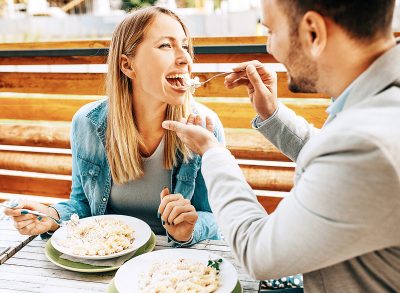 Young couple enjoying restaurant and eating pasta.