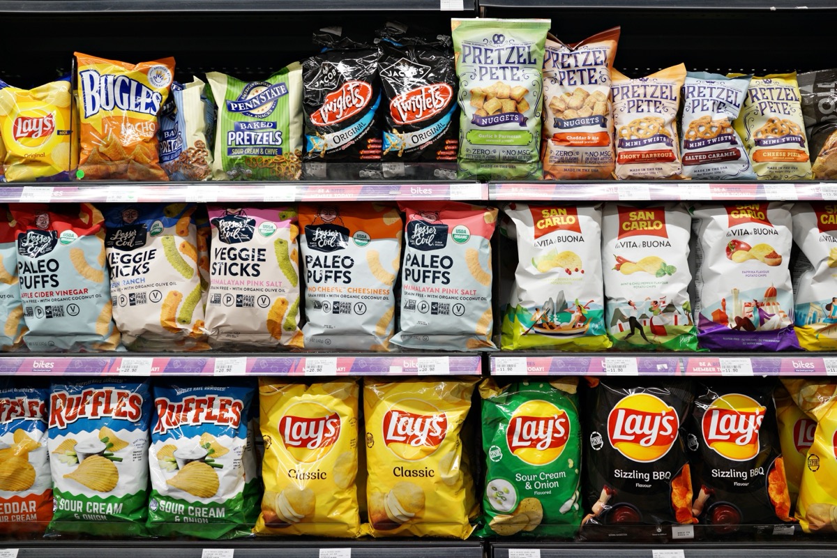 SELANGOR, MALAYSIA - 27 FEB 2022. Various imported brands of flavoured chips and snacks on store shelf in Village Grocer store. Village Grocer is the coolest fresh premium supermarket in Malaysia.