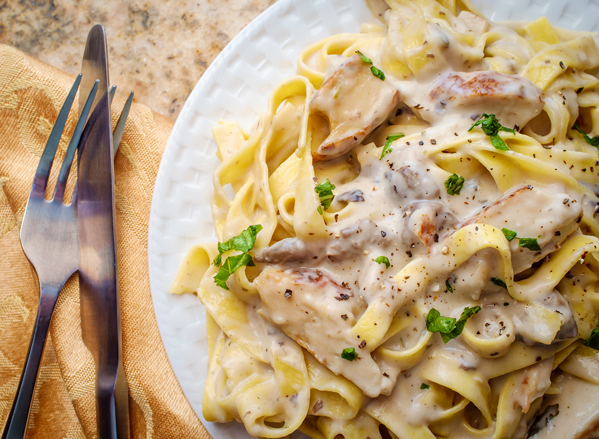 Authentic Italian fettuccine alfredo pasta dish with grilled chicken breast