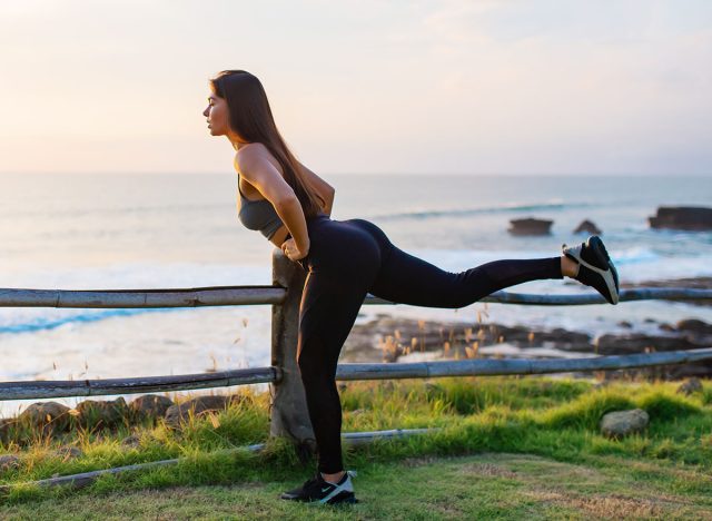 Outdoor sports. A happy young girl goes in for sports, does exercises in a park near the sea. The concept of a healthy lifestyle and recreation.