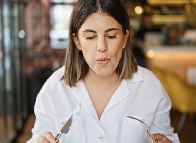 Young beautiful hispanic woman eating at the restaurant